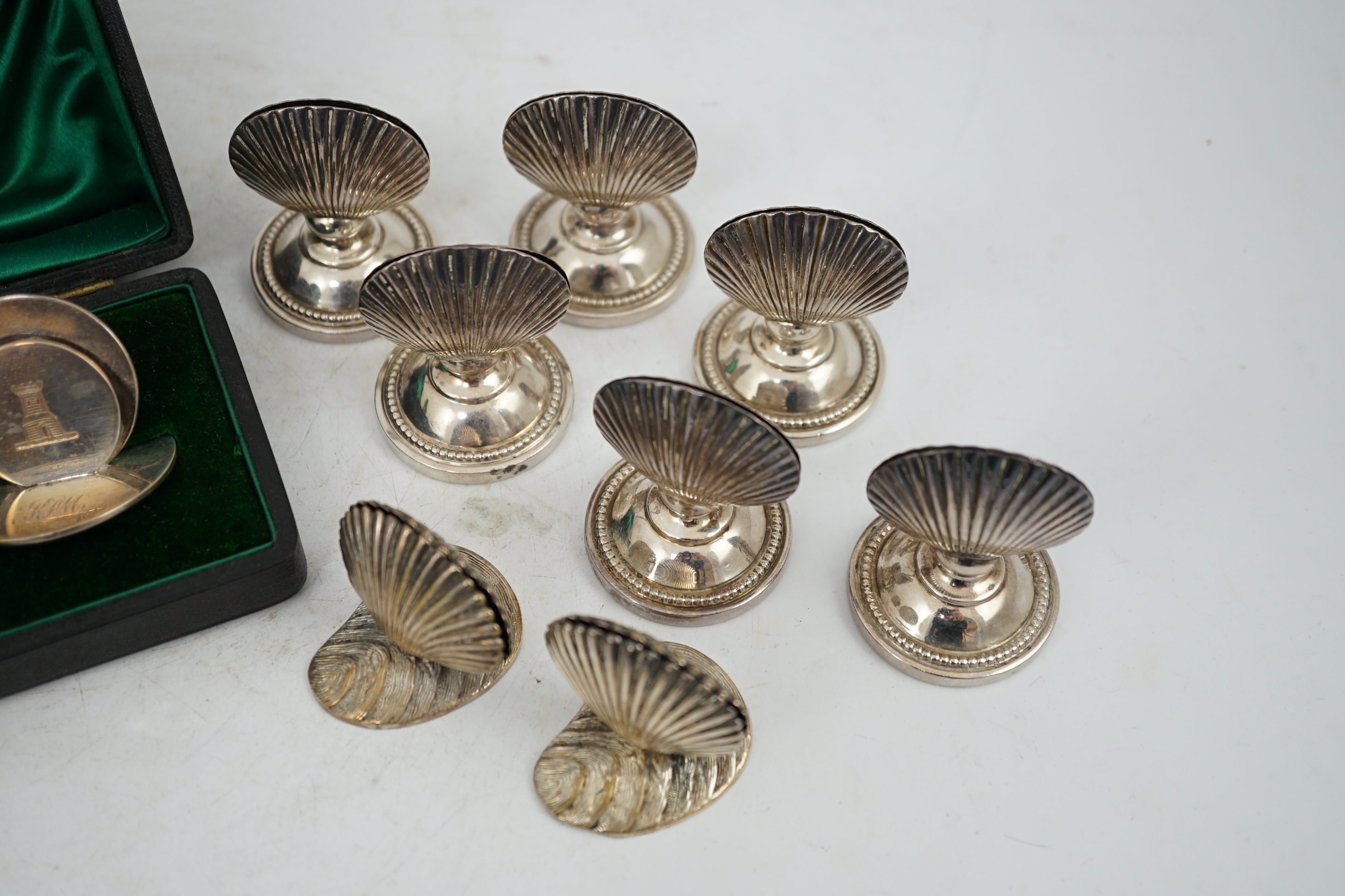 A cased set of four silver menu holders, engraved with castle crest, Sampson Mordan & Co, Chester, 1904, height 37mm, together with eight plated menu holders